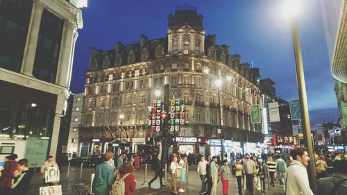 Crowd in city against sky at night