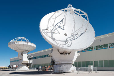 Low angle view of communications tower against blue sky