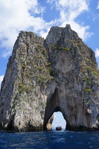 Scenic view of rock formation in sea against sky