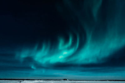 Scenic view of sea against dramatic sky at night