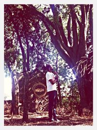 Woman standing on tree trunk