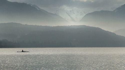 Scenic view of sea and mountains against sky