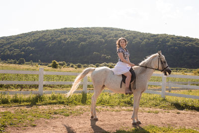 Full length of young woman riding horse