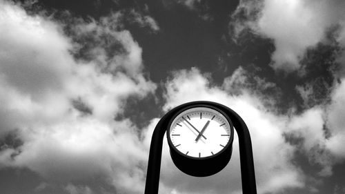 Low angle view of clock against sky