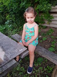 Full length of young woman standing against trees