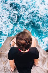 Rear view of boy standing in swimming pool