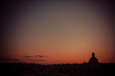 Silhouette buildings against sky during sunset