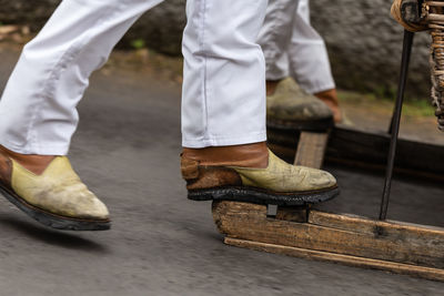 Low section of man running with sled on road