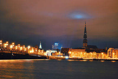 River with illuminated buildings in background at night