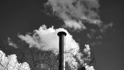 Low angle view of smoke emitting from chimney against sky