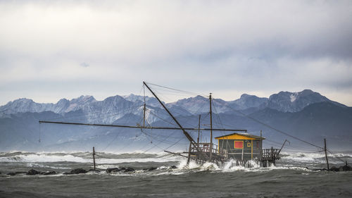 Scenic view of snowcapped mountains by sea against sky