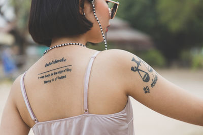 Woman with tattoo standing outdoors