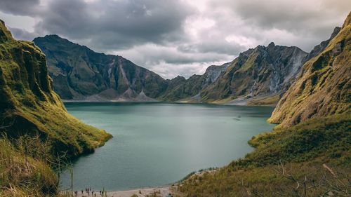 Scenic view of lake by mountains against sky