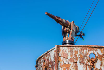 Low angle view of abandoned ship against clear blue sky