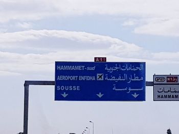 Close-up of road sign against sky