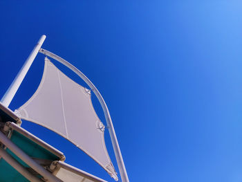 Low angle view of ferris wheel against clear blue sky