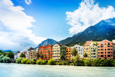 Buildings by mountains against sky