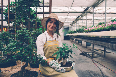 Portrait of young woman standing in greenhouse