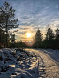 Scenic view of snow covered landscape against sky during sunset