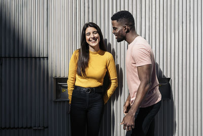 Young couple standing against wall