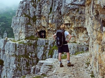 Rear view of man standing by rock formation