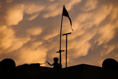 Low angle view of silhouette building against sky during sunset