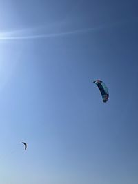 Low angle view of person paragliding against sky