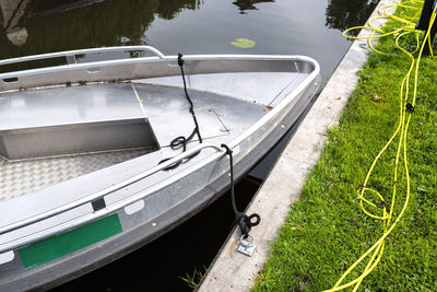 Metal boat moored in the channel is connected with a cable to a socket in order to charge batteries.