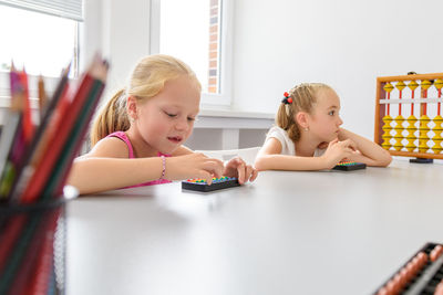 Learning difficulty. girls doing playful exercises during math tutoring session.