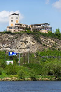 Information sign by building against sky