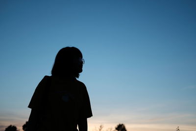 Silhouette woman looking at sunset