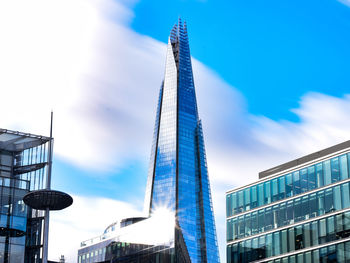 Low angle view of skyscrapers against blue sky