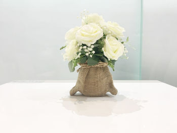 Close-up of white roses in vase on table