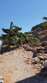 Low angle view of rocks against clear blue sky