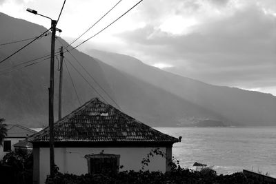 Lifeguard hut by sea against sky