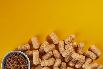 High angle view of roasted coffee beans on yellow background