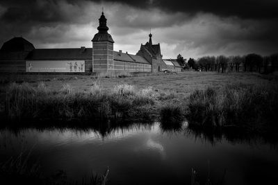 Historic building by lake against sky