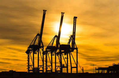 Low angle view of cranes against sky