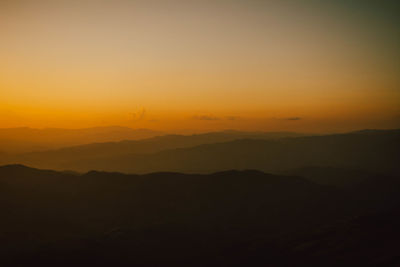 Scenic view of silhouette mountains against sky during sunset