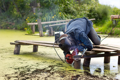 A welder in a blue uniform, red protective gloves and a mask. welding work in extreme conditions.