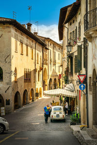 People on street amidst buildings in city