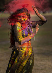 Smiling woman playing holi outdoors