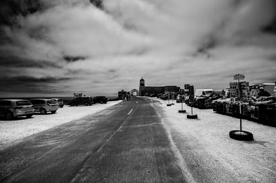 Cars on road against sky in city