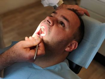 High angle view of dentist examining man