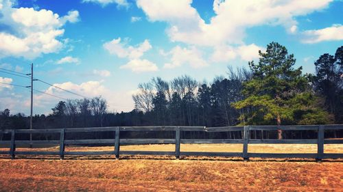 Fence on field against sky