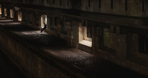 High angle view of person sitting by sidewalk