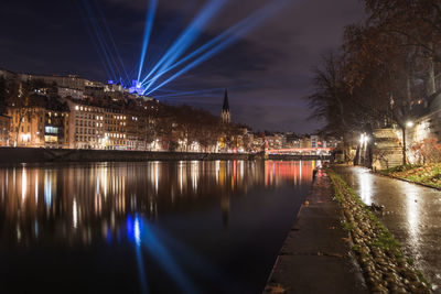 Illuminated bridge over river at night