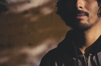 Portrait of young man looking away outdoors