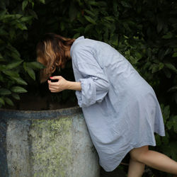 Side view of woman standing by plants