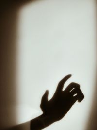 Close-up of hand touching shadow on wall